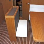 AMPLIANDO ESPACIO El mueble central de servicio y estiba contiene una banqueta desplegable que amplía la capacidad de la mesa.