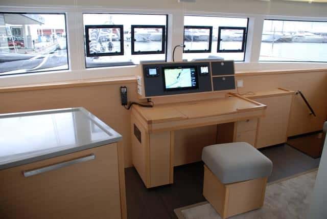 Los interiores y la distribución no varían respecto a la versión con flybridge. Mesa de cartas central, cabinas con camas dobles exentas y acceso a la cabina de popa del casco de babor desde la bañera.